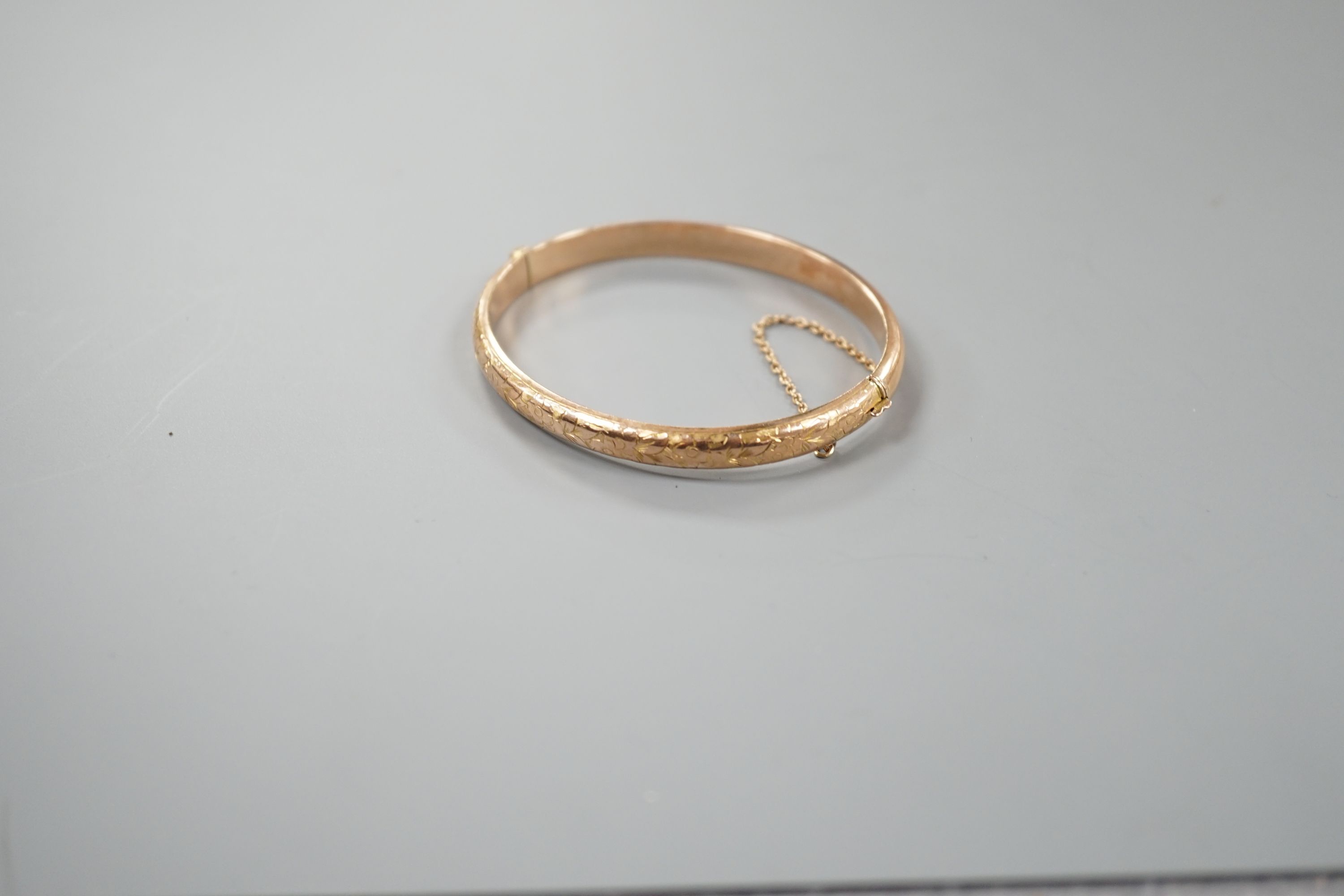 An engraved hollow 9ct gold bangle, 7.6 grams.